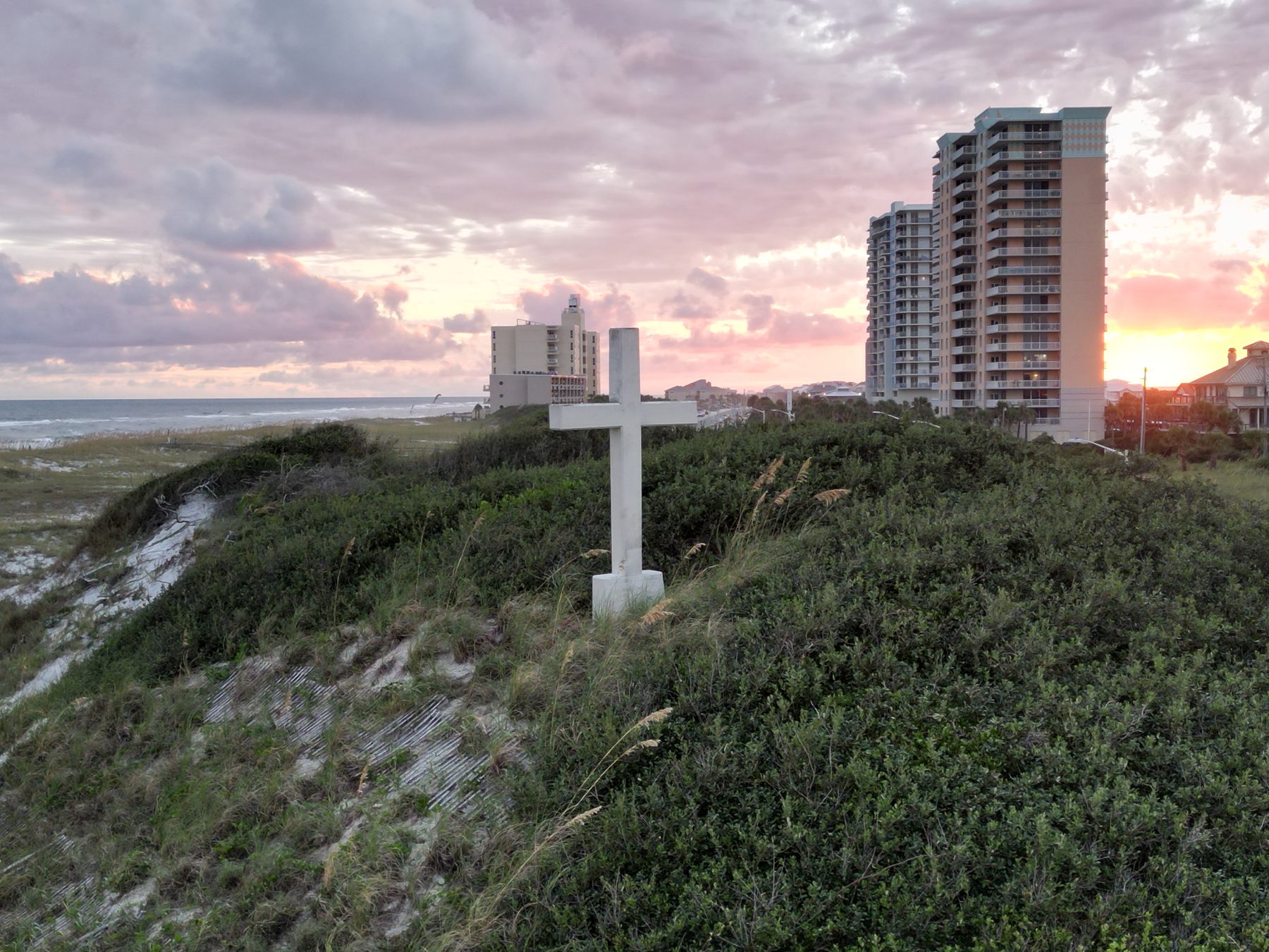 Wide drone view of the beach cross and dunes at sunset on Pensacola Beach
