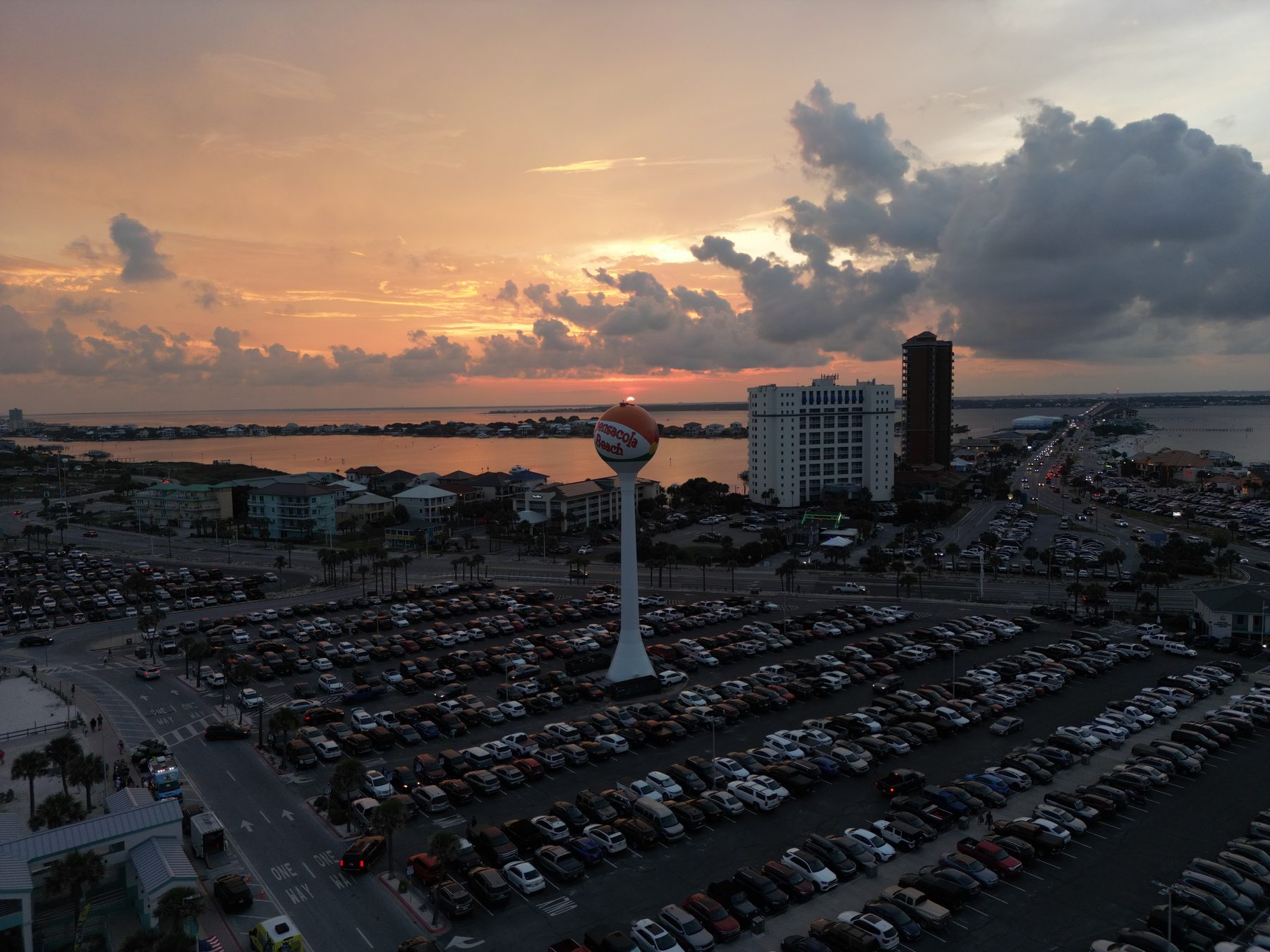 Pensacola Beach at dusk from the air, with the beach-ball water tower and Gulf horizon in view