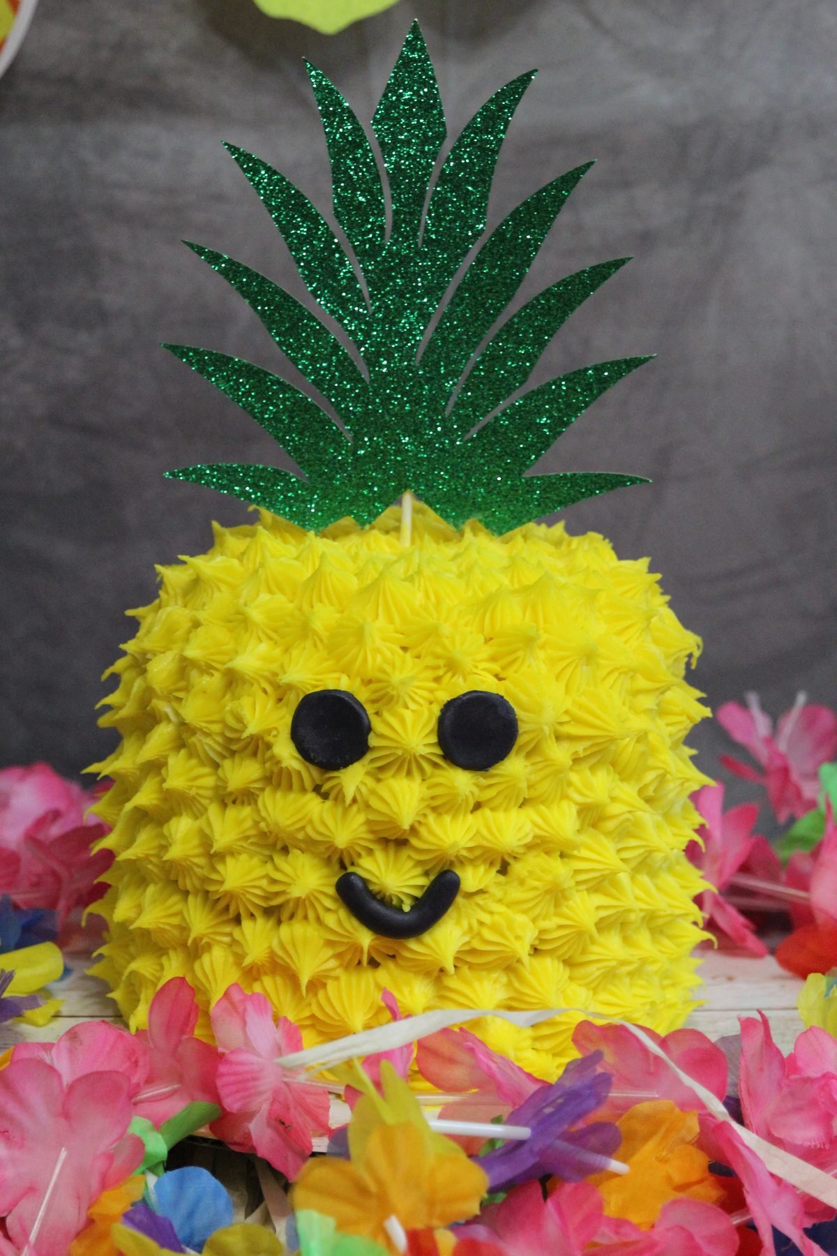 Smiling pineapple party prop styled with silk flowers for an event brand