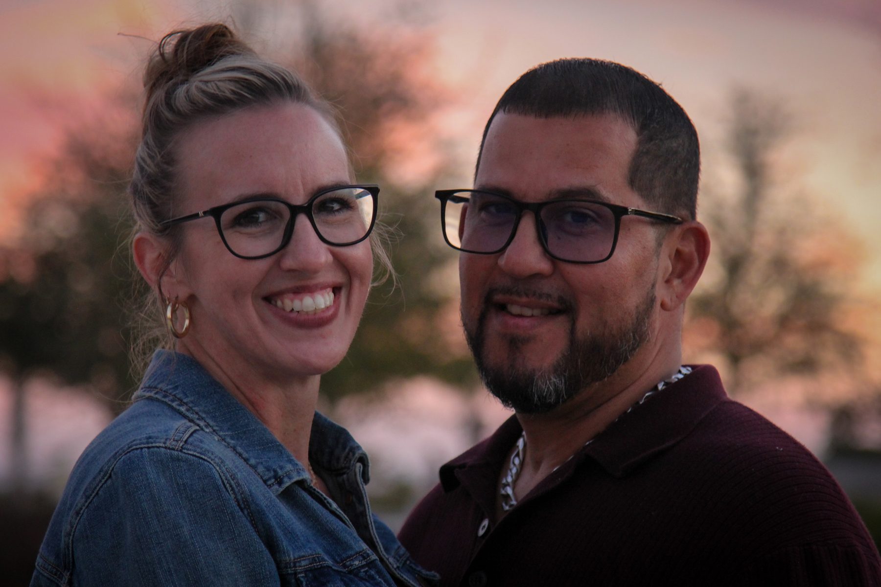 Smiling couple close together during a warm evening session