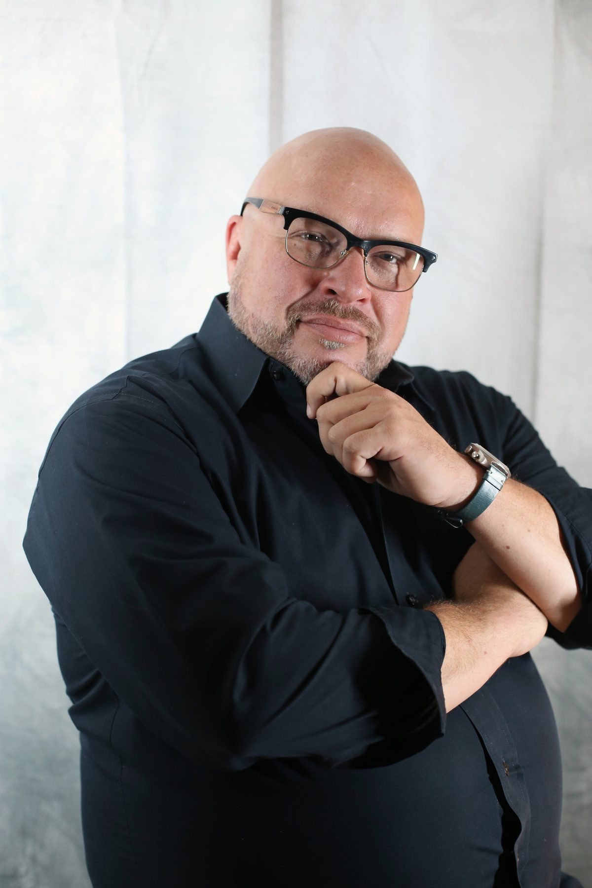 Studio executive portrait of a businessman in black with arms crossed