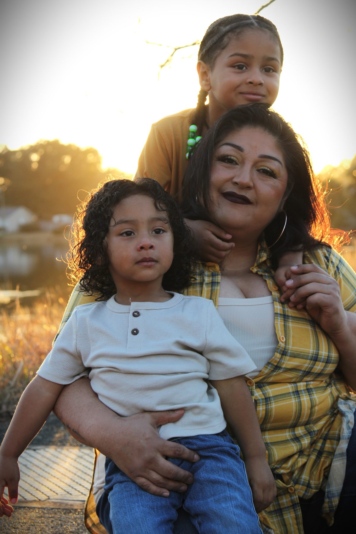 Mother holding her two children in warm evening light