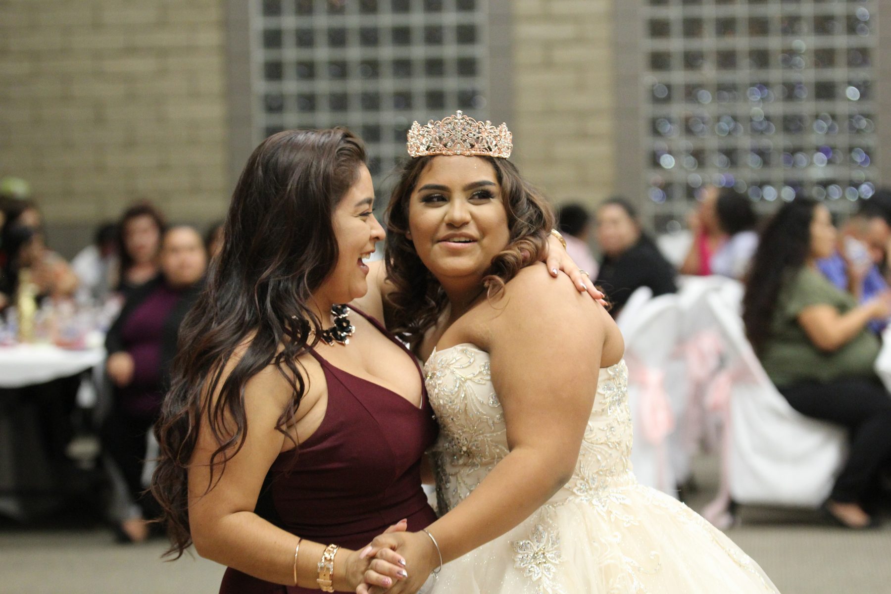Quinceañera celebrating with a guest between reception tables