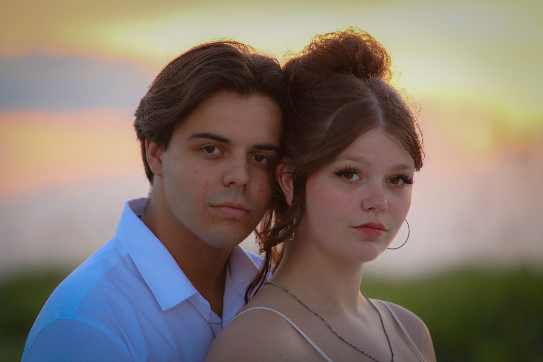 Young couple cheek to cheek against a pastel Gulf Coast sunset